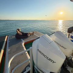 a large dual motor vessel with a floatables inflatable pontoon dock out the back creating extra space on the water for the man sitting on the platform